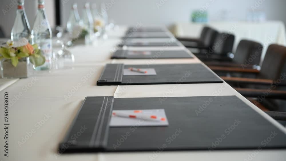 Rack focus along notepads on conference table Rack focus along notepads on conference table