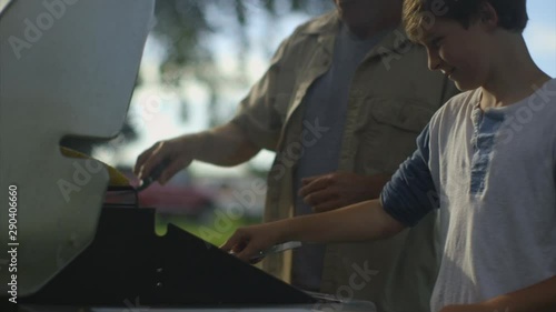 Caucasian father and son grilling outdoors