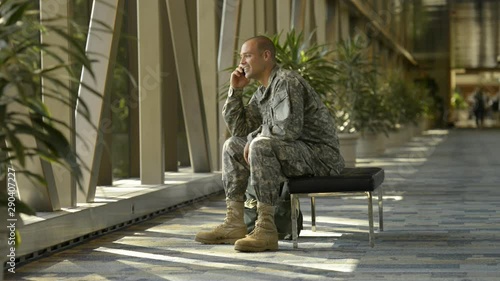 Caucasian soldier talking on cell phone in airport