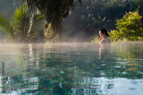 A young woman relaxing in an infinity pool © Peter Austin