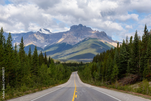 Scenic Empty road in the Canadian Rockies during a vibrant sunny and cloudy summer morning. Taken in Icefields Parkway, Banff National Park, Alberta, Canada.