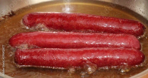 Delicious sausages frying in a pan