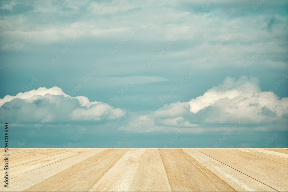 Wooden table top on blue sky with clouds for background