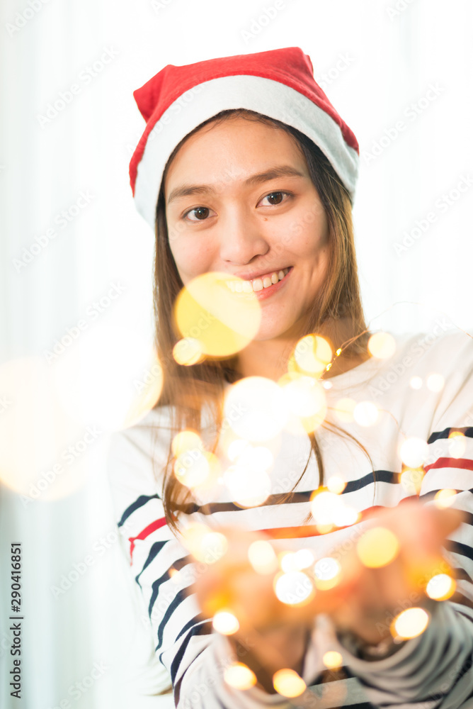 Beautiful cute young santa woman with bokeh light.