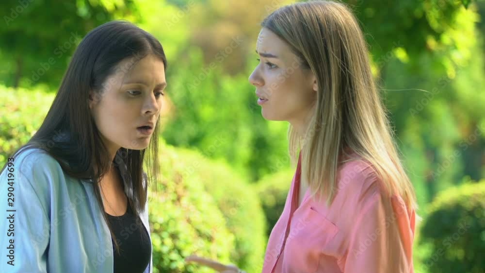 Angry female friends arguing and quarreling in park, friendship relations crisis Angry female friends arguing and quarreling in park, friendship relations crisis
