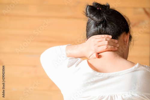 Woman feeling exhausted and suffering from neck pain.