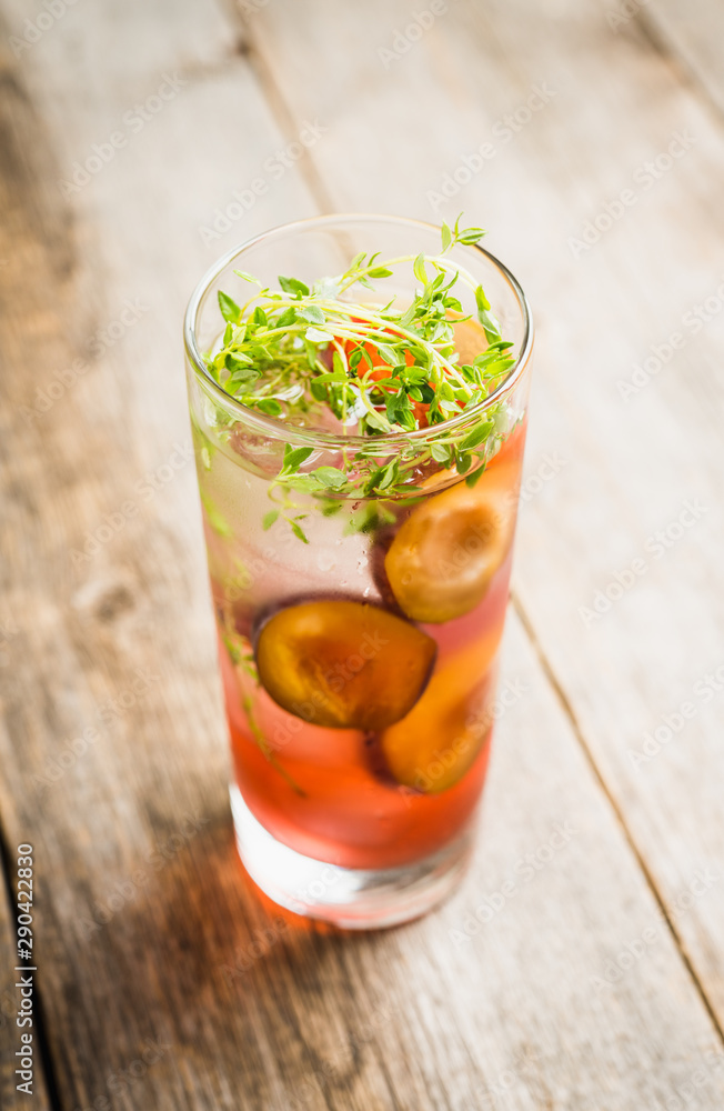 Cocktail with plums and thyme on the rustic background. Selective focus. Shallow depth of field. Cocktail with plums and thyme on the rustic background. Selective focus. Shallow depth of field.