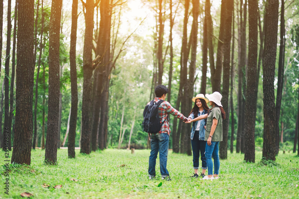 Closeup image of travelers putting their hands together in the forest