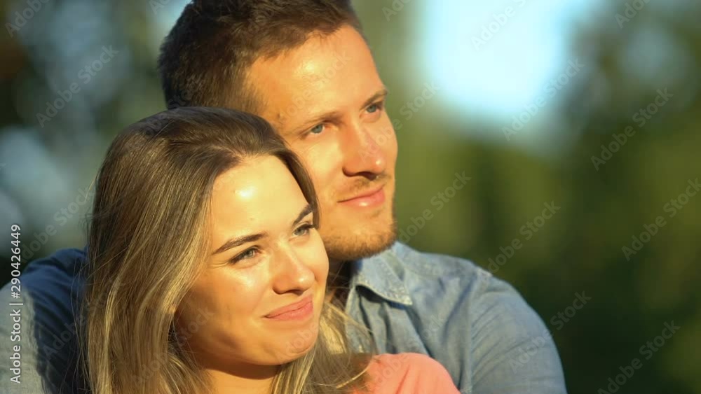 Beautiful young couple cuddling watching sunset over city, romantic moments Beautiful young couple cuddling watching sunset over city, romantic moments