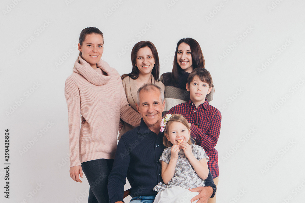 concept of happy childhood, family, love - group of people on a white background: adults and children with toys sitting on the same couch concept of happy childhood, family, love - group of people on a white background: adults and children with toys sitting on the same couch