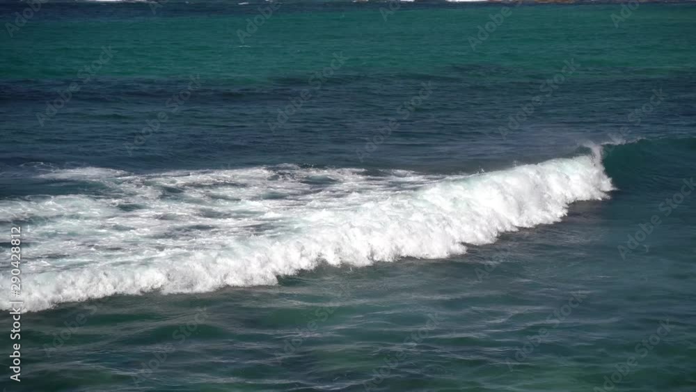 Large blue pacific ocean waves crashing into shoreline rocks on coast to beach on windy summers day Large blue pacific ocean waves crashing into shoreline rocks on coast to beach on windy summers day