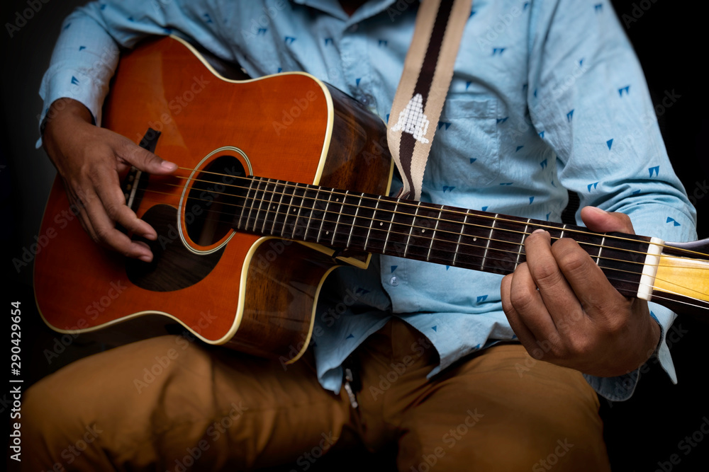 Male Guitar Musician Playing His Acoustic Guitar iSolated Black Background.