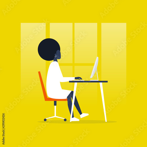 Young black female manager sitting at the computer