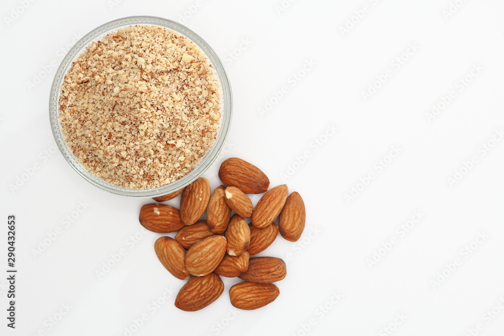 Whole and ground raw almonds on white background.. Whole and ground raw almonds on white background..