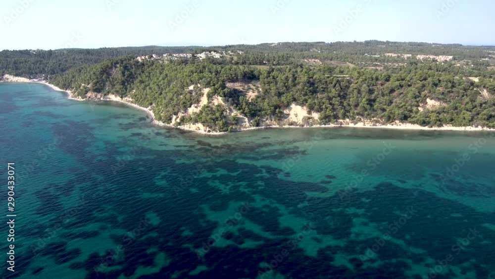 Aerial view of coastline with small turquoise beach under rock with trees, Siviri Halkidiki, Greece, side movement by drone Aerial view of coastline with small turquoise beach under rock with trees, Siviri Halkidiki, Greece, side movement by drone