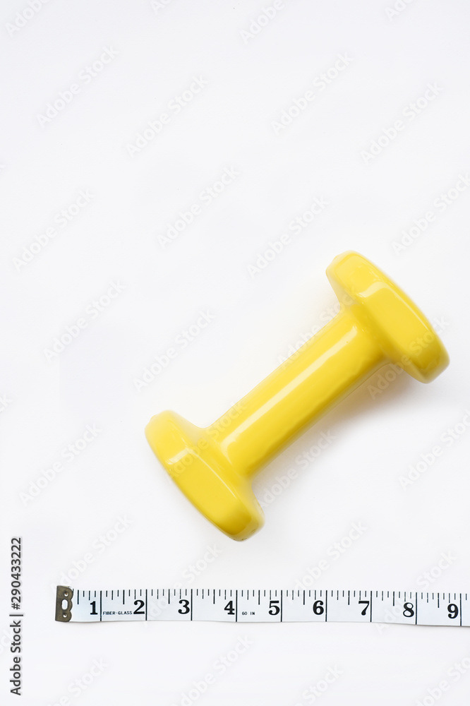 Fitness concept dumbbell and measuring tape isolated on white background Fitness concept dumbbell and measuring tape isolated on white background