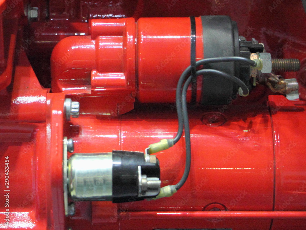Electrical and retractor relay on red electric stater device on new truck motor engine close up Electrical and retractor relay on red electric stater device on new truck motor engine close up