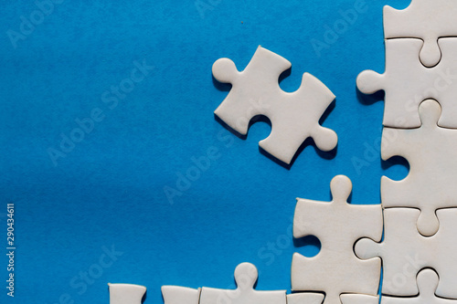 Unfinished white jigsaw puzzle pieces