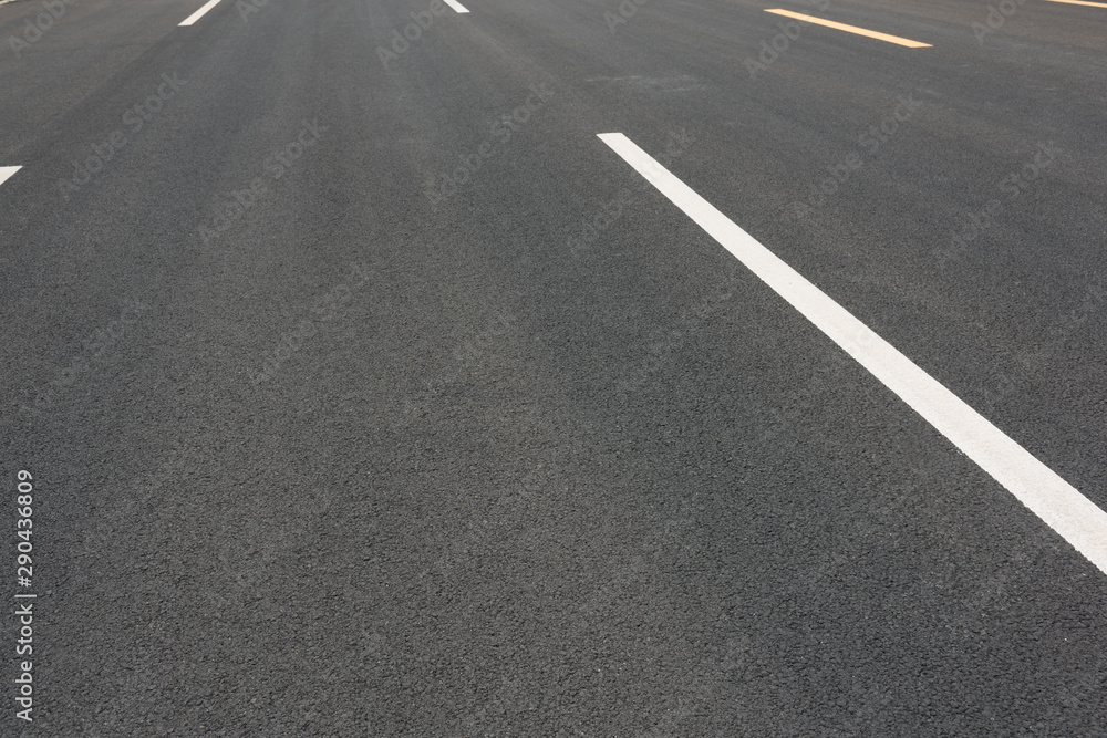 Wide asphalt road pavement and white paint line low angle view background