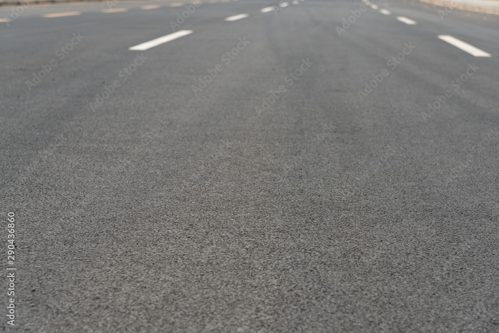 Wide asphalt road pavement and white paint line low angle view background Wide asphalt road pavement and white paint line low angle view background