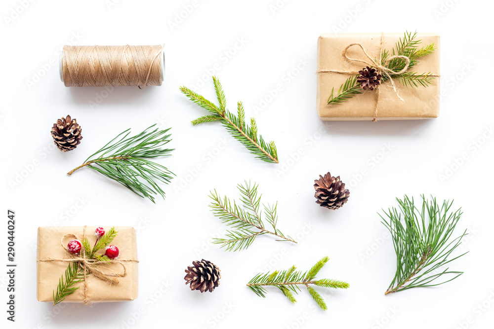 Winter festive layout with spruce branches and New Year presents on white background top view flat lay Winter festive layout with spruce branches and New Year presents on white background top view flat lay