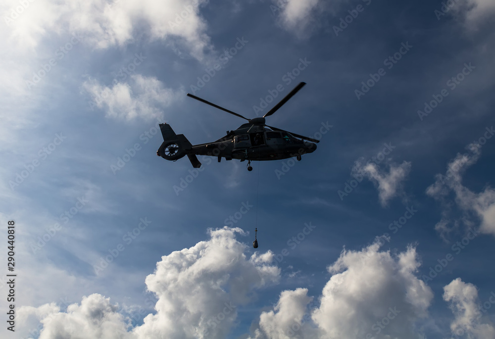 Fototapeta premium Military helicopter flying over clouds. Nato exercise in black sea. 