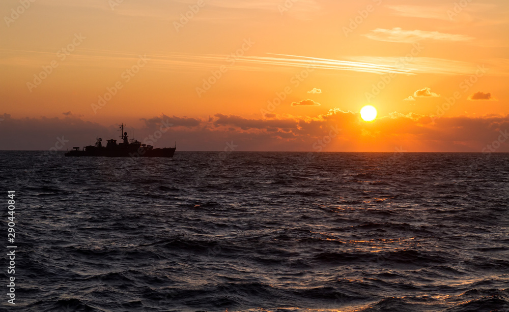 Navy military ship sailing during sunrise at the black sea. Patrol and protect maritime borders.