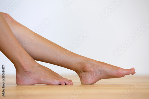 Woman bare feet on the floor. Legs care and skin treatment concept. © bilanol