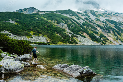 Fototapeta Naklejka Na Ścianę i Meble -  Young man try a water in Beautiful lake in Tatra mountains. Poland