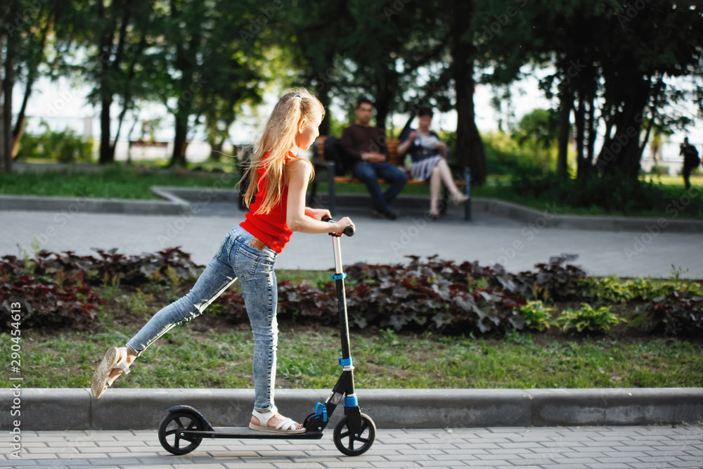 Teen Child riding a scooter in a city park. Teen Child riding a scooter in a city park.