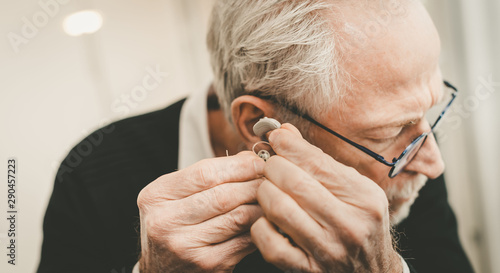 Man putting hearing aids photo