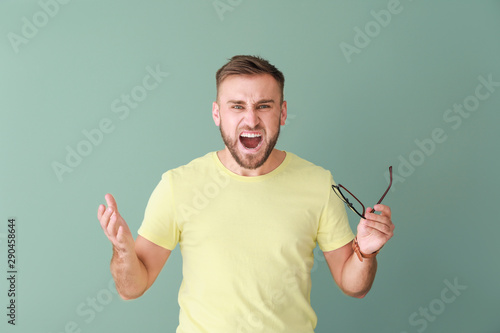 Stressed young man on color...