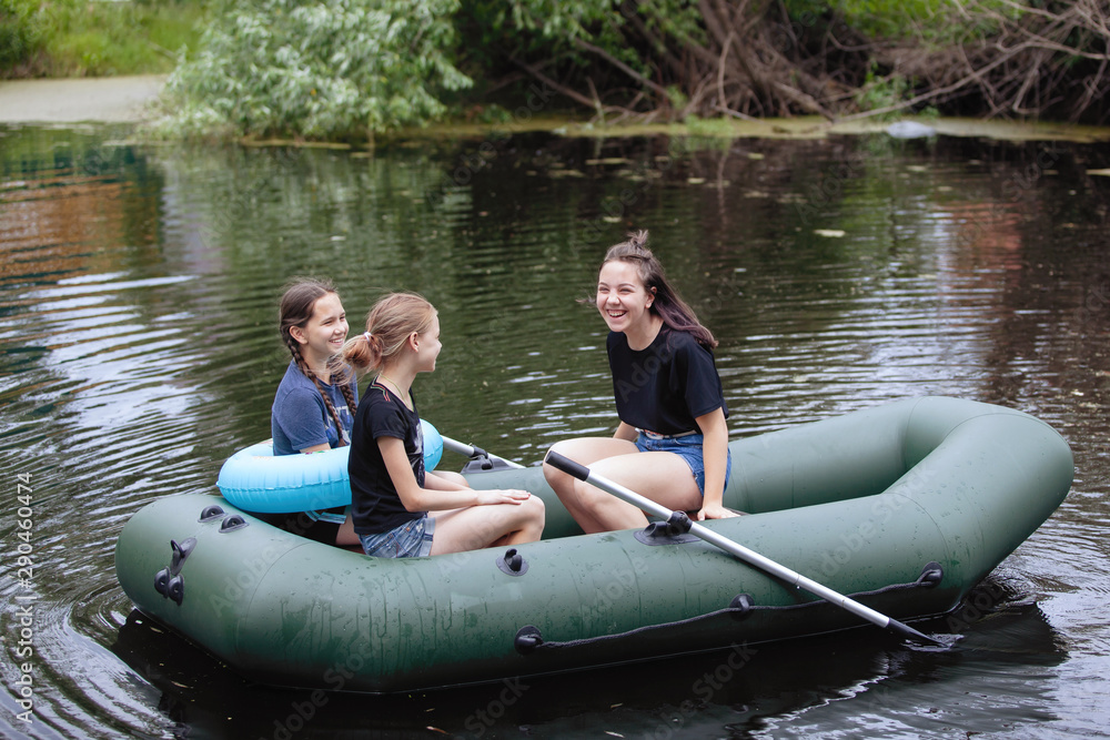 Children ride an inflatable boat on the lake Children ride an inflatable boat on the lake
