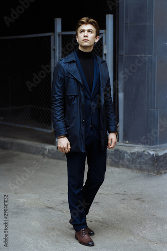 portrait of an attractive young man in a blue suit in the city