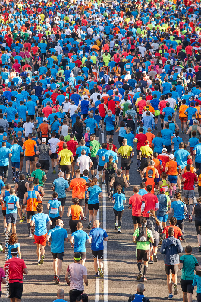 Runners on the street. Athletes in motion. Urban competition. Crowd