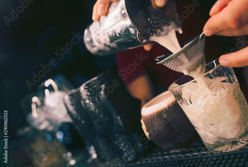 Bartender pouring using strainer. Trendy stylish club alcoholic Sweet healthy Cocktail on a bar counter view . Copy paste for design people and luxury concept service barman in nightclub