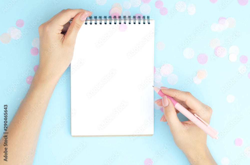 Female hands write something in a notebook. Female hands write something in a notebook.