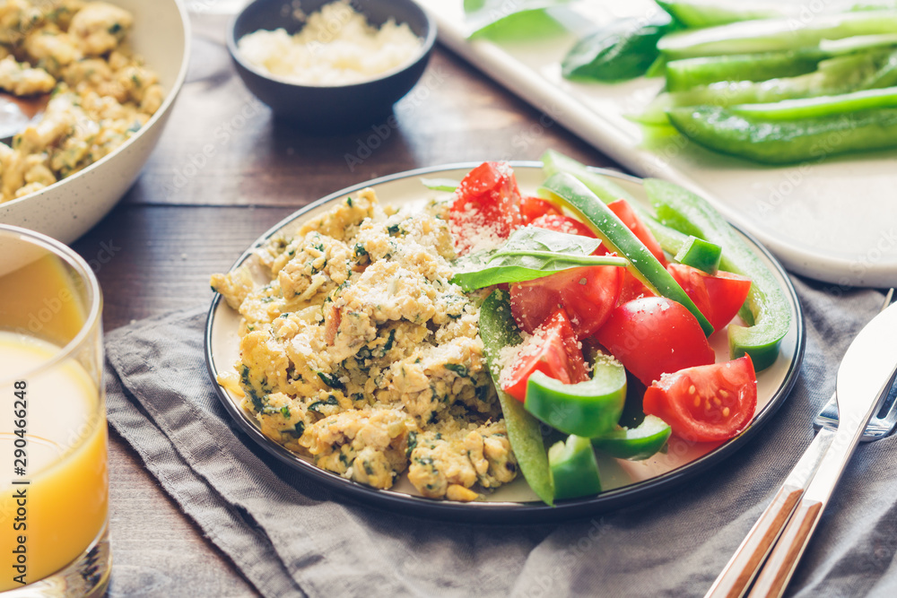 Breakfast table with a portion of spinach scrambled eggs served fresh vegetables. Healthy and fitness eating concept. Breakfast table with a portion of spinach scrambled eggs served fresh vegetables. Healthy and fitness eating concept.