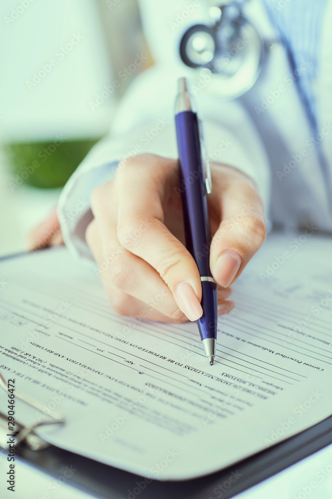 Female doctor hand hold silver pen filling patient history list at clipboard pad. Panacea and life save, prescribing treatment. Female doctor hand hold silver pen filling patient history list at clipboard pad. Panacea and life save, prescribing treatment.