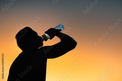 Fit male drinking from bottle of water. 