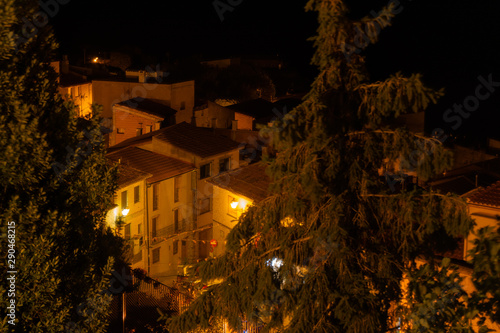 Vista nocturna de los tejados de las casas de un pueblo.
