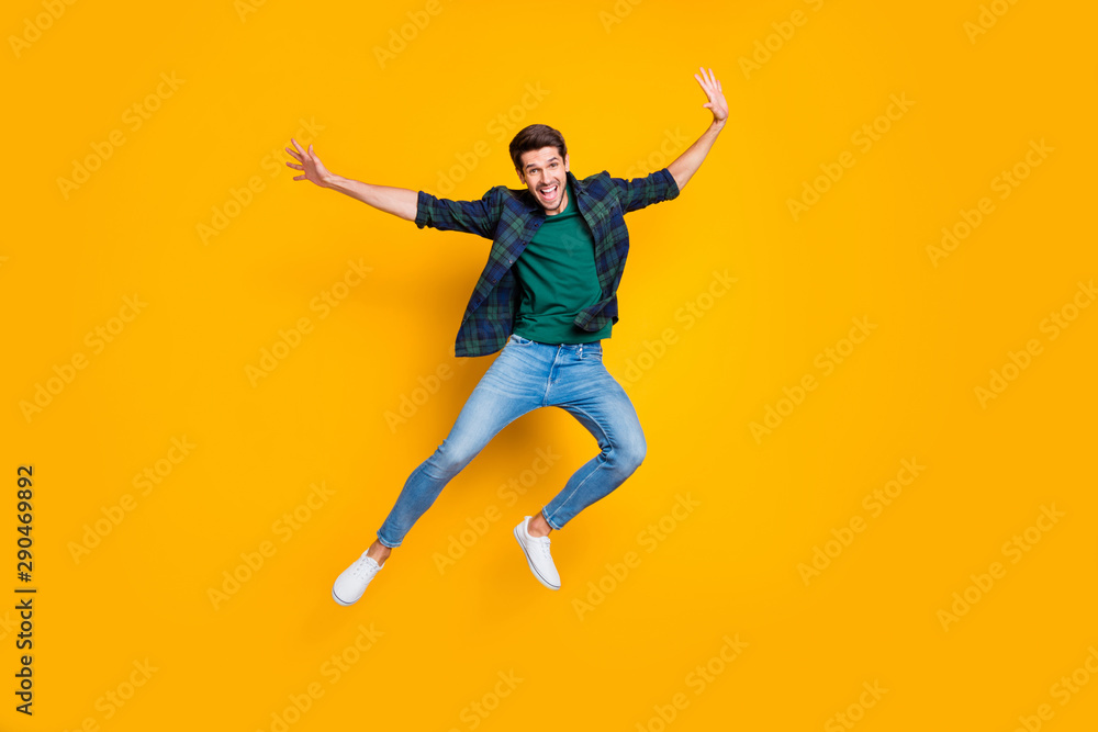 Full size photo of satisfied excited enthusiastic man jump enjoying free time on holidays good-looking wear modern trendy outfit isolated over yellow color background