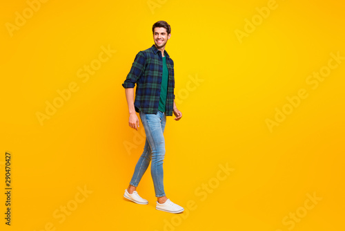 Full length body size photo of cheerful handsome man wearing jeans denim wearing footwear isolated vivid color background © deagreez