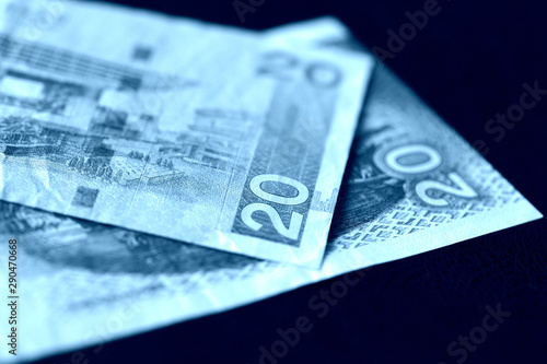 Two bills of twenty Hong Kong dollars on a dark background close-up. Blue color toned