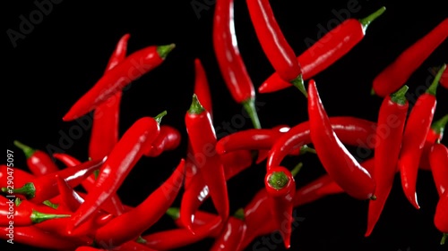 Super Slow Motion Shot of Flying Red Chilli Peppers in the Air at 1000fps. Shooted with High Speed Cinema at 4K. photo