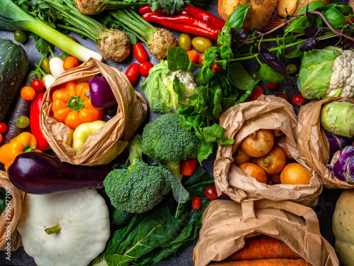  Garden produce and harvested vegetable. Fresh farm vegetables Zero waste and eco friendly shopping with vegetables and fruits in paper bags top view. Plastic free and reuse concept. photo