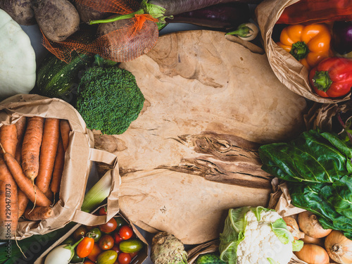 Variety of vegetables on wooden background, clean eating and dieting cconcept, Zero waste and eco friendly shopping, paper bags top view. Plastic free and reuse concept. Copy space photo