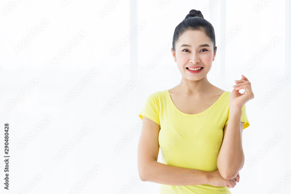 Portrait of a asian women workout practicing yoga in yellow dress and practice meditation wellness lifestyle and health fitness concept in a gym.