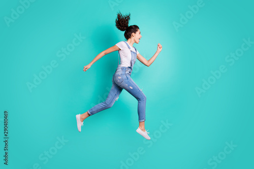 Full length body size view of nice attractive cheerful cheery glad excited purposeful wavy-haired girl jumping running fast isolated on bright vivid shine vibrant green turquoise background