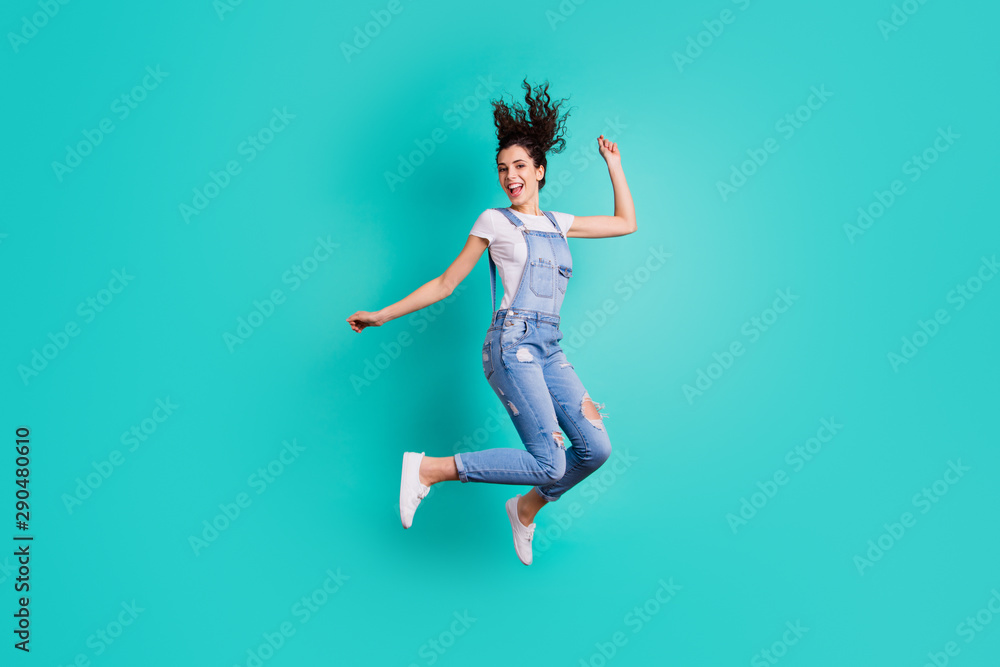 Full length body size view of her she nice attractive cheerful cheery glad carefree girl wearing overall jumping having fun free time isolated on bright vivid shine vibrant green turquoise background Full length body size view of her she nice attractive cheerful cheery glad carefree girl wearing overall jumping having fun free time isolated on bright vivid shine vibrant green turquoise background